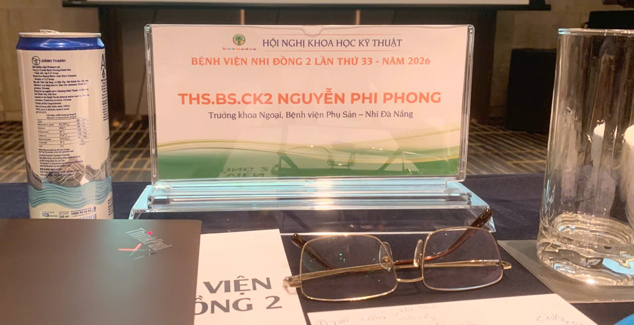 Bảng tên ThS.BS.CK2 Nguyễn Phi Phong, Trưởng khoa Ngoại Bệnh viện Phụ sản – Nhi Đà Nẵng, trên bàn chủ toạ Hội nghị Khoa học Kỹ thuật Bệnh viện Nhi Đồng 2 lần thứ 33